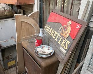 cabinet, marlboro sign, old swinging doors, shutters and other items on back porch area of house