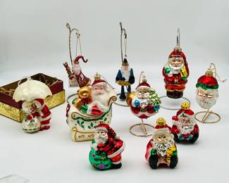 (10) Delicate Santa Christmas Ornaments
Most of these are old world style, lightweight, puffy, mouth blown, hand painted, extremely delicate Christmas ornaments. One of the puffy Santas is marked "A" on the bottom, and another says "AMERICHRISTMAS" on top, both as shown. This lot includes: Santa Riding in Sleigh Glass Christmas Ornament Large 6", a beautiful vintage piece. Scottish Christmas Vision of Sugarplums Mr & Mrs Claus Under Umbrella Handblown Ornament, which has some damage underneath the umbrella where it meets the pole, shown. The Flying Elf Santa, new with tags and still in artisanal original box. And many more!

