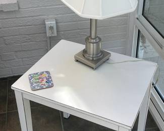 White end table with lamp.