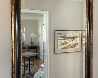 Rococo-style ebonized giltwood mirror.