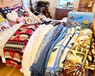 Bed full of blankets, comforters & pillows.