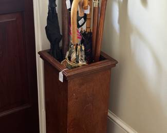 umbrella stand with umbrellas, walking sticks and canes