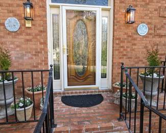 Front door, with faux cast iron (plastic) planters with freshly  planted pansies and violas.