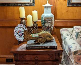 One of a pair of hand-carved wooden side tables, with single drawer/two doors, hand-carved gold-painted wooden fish, one of a pair of Asian porcelain table lamps and set of 3 pillar candles on stands. 