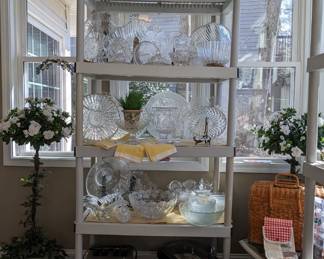 The sunroom with an amazing variety of kitchen treasure! This unit has a collection of glass serving items, including platters, bowls, domed cake stand, as well as decorative items, and small kitchen appliances.