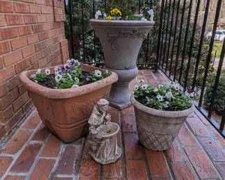 Close-up of thef aux cast iron (plastic) planters with freshly  planted pansies and violas, right of front door.