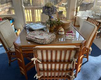 Rattan glass-top table with four matching rattan chairs.