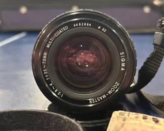 Vintage Canon AE-1 35mm film camera with Sigma 35-70mm lens, Sunpak flash, and accessories.