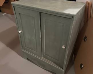 gray/green wood cabinet with white pulls