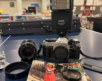 Vintage Canon AE-1 35mm film camera with Sigma 35-70mm lens, Sunpak flash, and accessories.