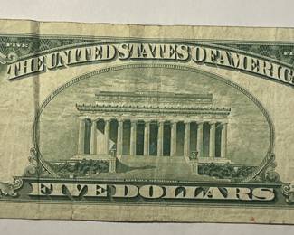 Five dollar bill missing “in god we trust”