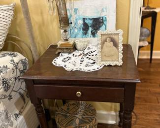 Bedside table, wastebasket, crochet scarf, lamp, pictures