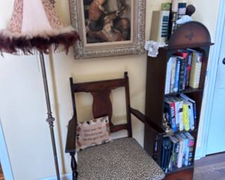 Metal stand lamp . Vintage chair, bookcase with books, picture