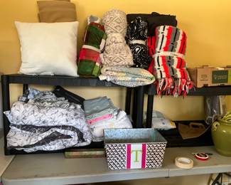 Bedroom on left - queen comforter & sheet set, afghans, Additional sheet sets, pillowcases, and crochet items along with scarves. 