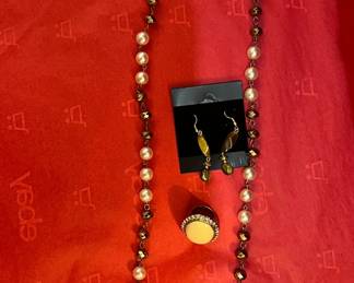 Earrings with brown stones.
Gold ring with cream stone and diamond studs around.
Necklace brown and rose gold beads.