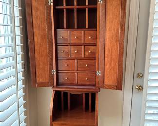 A tall, narrow secretary desk with sorting slots, drawers and pigeon holes similar to a postal cabinet.19.0" W x 77.25" H x 15.0" D