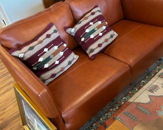 Copenhagen leather loveseat in persimmon leather.  One of many Oriental rugs.