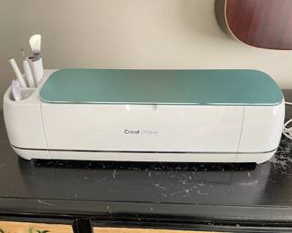 Cricut machine and tools with lots of extras, papers, vinyl, etc.