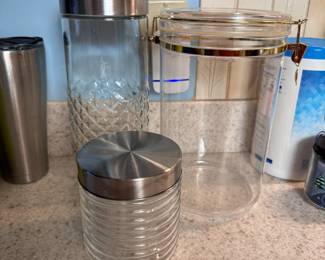 Two glass and 1 clear plastic canisters, tallest is 11"