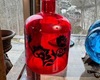 Red bottle with black floral pattern 5"H