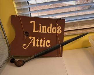 Artist's wooden sign with paint brush 'Linda's Attic', width is 24"