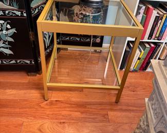 Brushed brass color metal table with glass top and lower shelf 22"H x 20"W