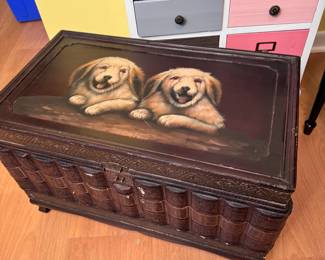 Wooden trunk with bookend sides and puppies on the lid, some chips and dents, handles missing 13"H x 14"D x 24"L
