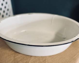 White metal washbasin with black rim.