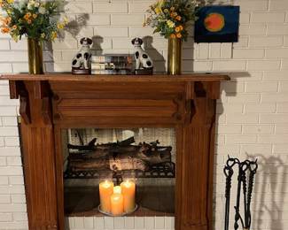 Hand-Carved Pine Fireplace Mantel  and Wrought Iron tools — never used. Pair of and English China Dogs. Two Brass vases hand-made from WWII Shells. 