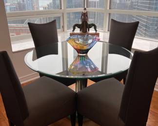 Full picture of contemporary glass dining table and 4 upholstered chairs.