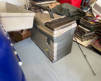 A dozen or so tackle boxes, some are still stocked some are empty.