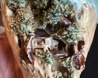 small village carved sculpted in the side of a vase