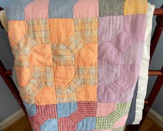 Vintage handmade quilt on quilt rack.