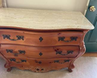 Three-drawer dresser with marble top.