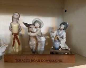 C32 - Lladro Figurines. Left to Right. $25. "Naughty Girl" no issues noted. $40. "Platero & Marcelino" no issues noted. $30 Geisha Flower Arranging - flowers are out of her hands and in vase. 