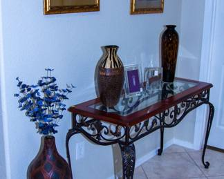 Intricate glass top table with display vases and artwork