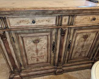 $175 Hooker Furniture Seven Seas credenza. This French Provincial credenza in a distressed off white finish features two drawers to the center, with embossed hardware knob pulls and double cabinet doors to the center; with ornate elongated hardware. This credenza features painted floral, botanical and garland motifs to the top, drawers, and doors in additional hues of pink, olive green and brown.
Glass top has a small chip on the front center edge.
42 inches tall 63 inches wide 20.5 inches deep
**Please bring adequate manpower to load into your vehicle. This item will be brought from the house to garage for easier pickup, but it is your responsibility to load into your vehicle. There will not be additional help available.