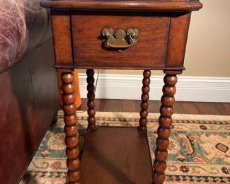 Living Room:  This is one of a PAIR of 30" tall English-style small side or lamp tables.  Each has a scalloped raised edge, one drawer, bobbin-style legs, and an under-shelf.  It is attributed to the "Jonathan Charles" design.   The next photo shows a side view.