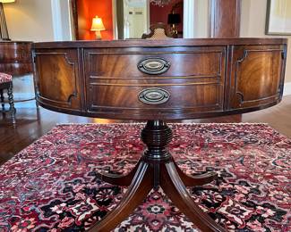 Foyer:  The 36" round antique drum table on casters has an embossed leather top and one real double drawer.  The other three "drawers" do not open.  