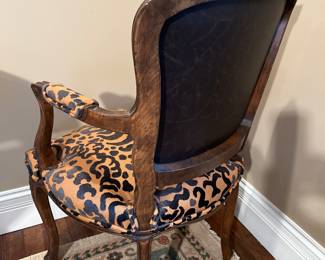 Living Room:  The back of the antique Louis XV-style armchair has black "leather" upholstery rather than the animal print that is on the front.