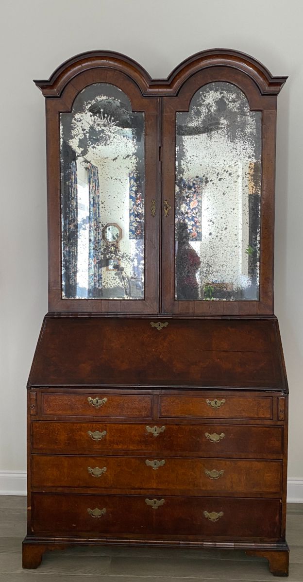 Late Queen Anne or early George I Bureau Cabinet, walnut and burr walnut, double domed mirrored doors, fall front, fitted interior, bracket feet, brass loop handles with engraved backplates, c. 1700-1720, 92" high, 45" wide and 22" deep, some veneer loss, otherwise good condition.
