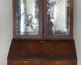 Late Queen Anne or early George I Bureau Cabinet, walnut and burr walnut, double domed mirrored doors, fall front, fitted interior, bracket feet, brass loop handles with engraved backplates, c. 1700-1720, 92" high, 45" wide and 22" deep, some veneer loss, otherwise good condition.