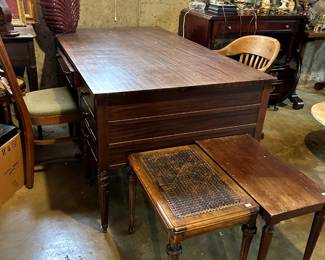 A beautiful partner's desk and many interesting side tables, chairs, and other pieces of furniture