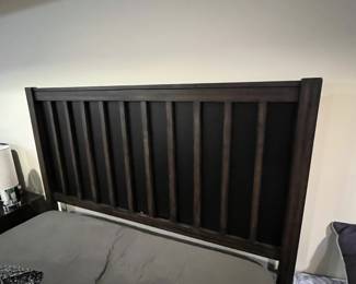 Full size bed frame with headboard . 2 small cracks in black laminate backing behind wood slats on headboard. 