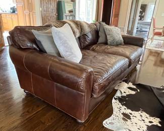 Restoration Hardware leather sofa with bun feet. 2 cushions, extra deep. Front left bottom corner has very slight scuffing. 97w x 48d at arm x 36h Excellent, barely used condition, purchased in May 2023.