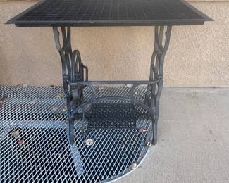 Unusual outdoor table made from sewing machine base and furnace grate.  Conversation piece!