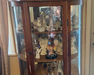 Curved Glass Curio full of decorative pieces