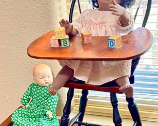 Crying little black girl Award winning Doll maker, porcelain doll and high chair.