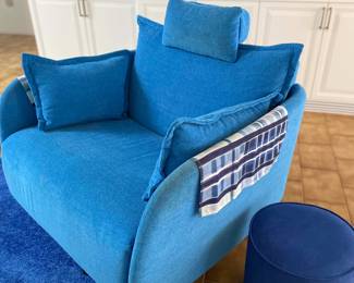 Electric blue recliner with coordinating ottomans and throw rug. 