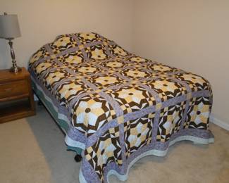 There is a queen bed hiding underneath the handmade quilt.